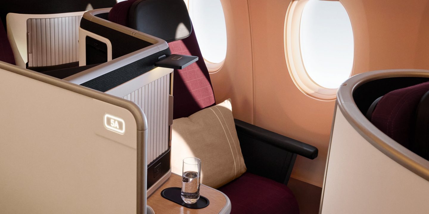 Luxurious business class cabin with private suite, comfortable seating, and window view.