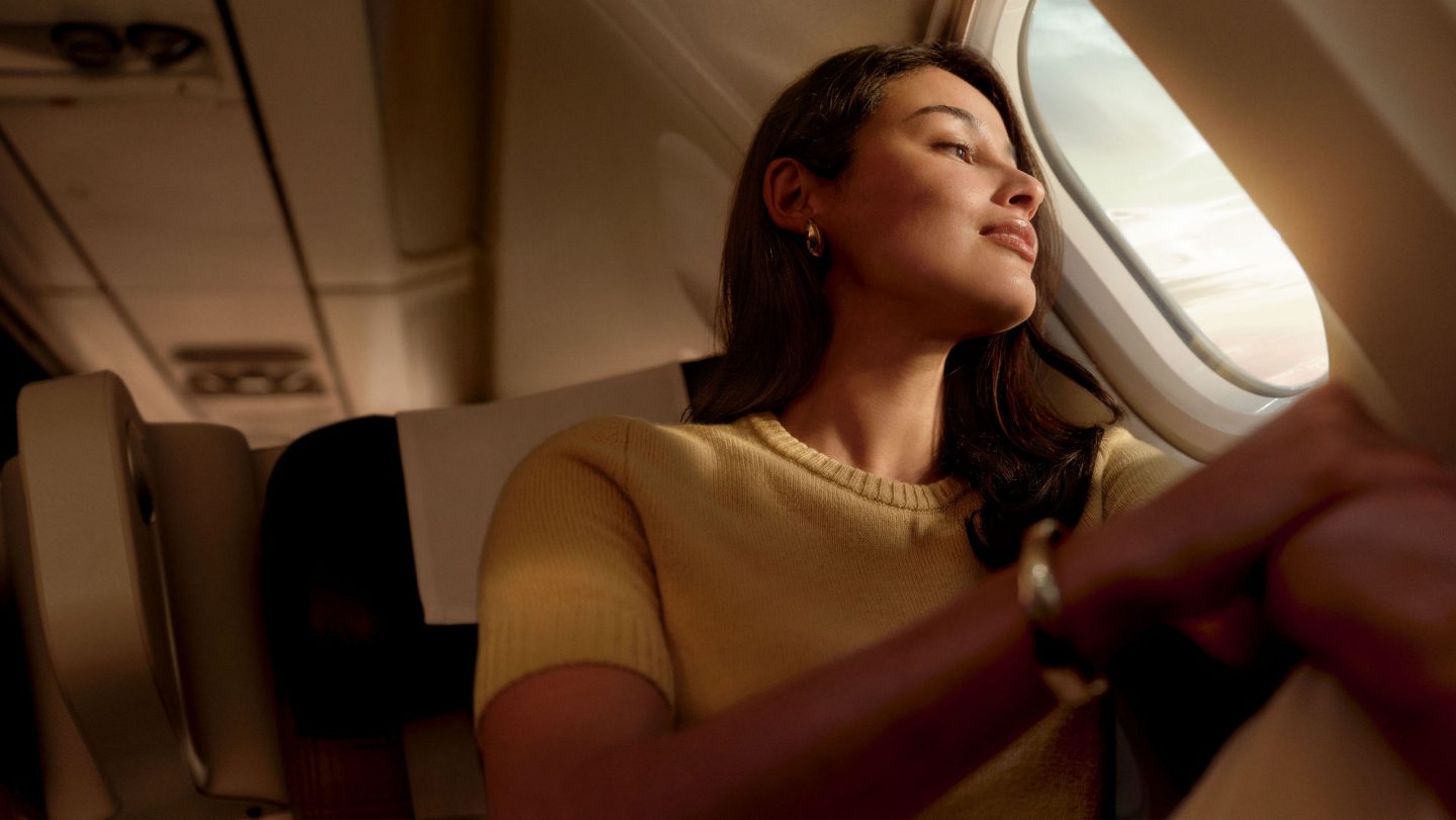Une femme regardant par le hublot d’un avion.