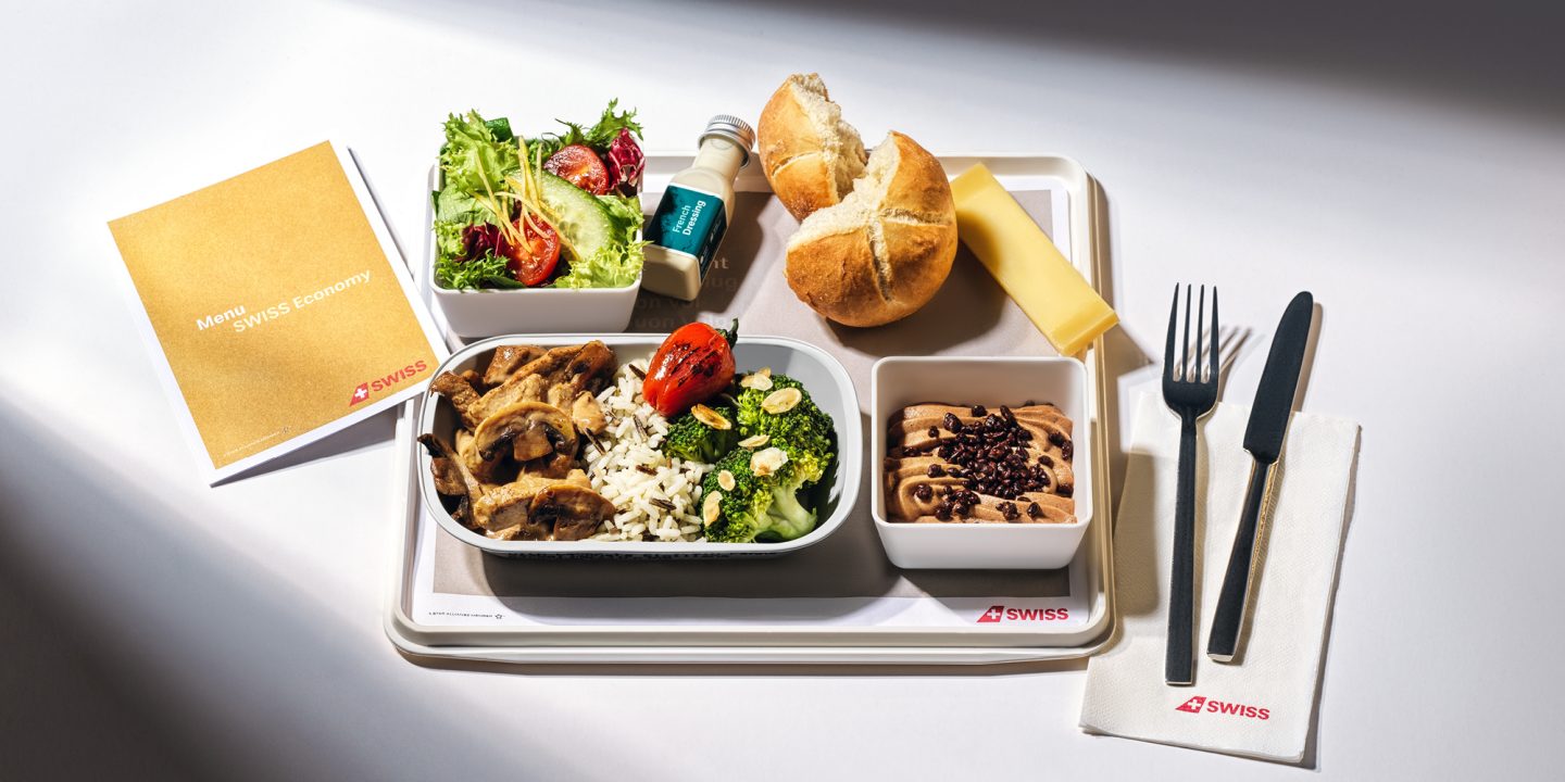 A food tray with utensils, commonly found on intercontinental flights.
