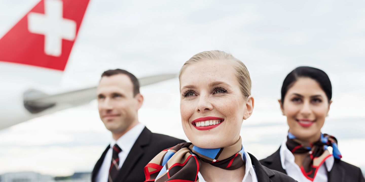 Three SWISS employees on the taxiway in front of a SWISS aircraft