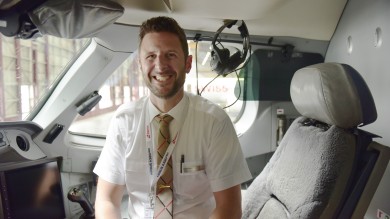Stephan sitzt im Cockpit und lächelt.