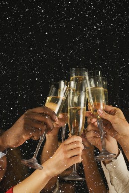 Christmas party time. Young people toasting with champagne flutes. Multiethnic friends congratulating each other with new year. Celebration and nightlife concept, holiday background, selective focus