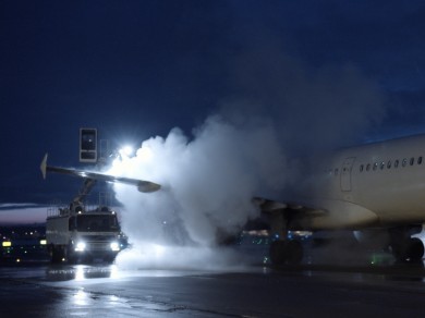Ein SWISS Flugzeug wird im dunkeln enteist. 