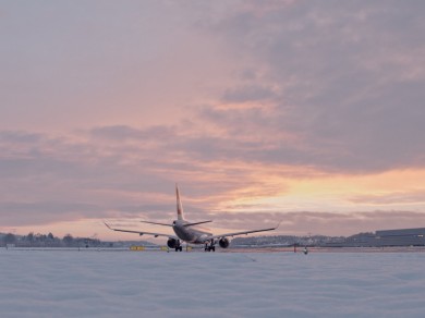 Ein SWISS Flugzeug rollt in den Sonnenuntergang.