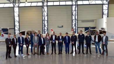 The delegation posing for a picture in the hangar. 