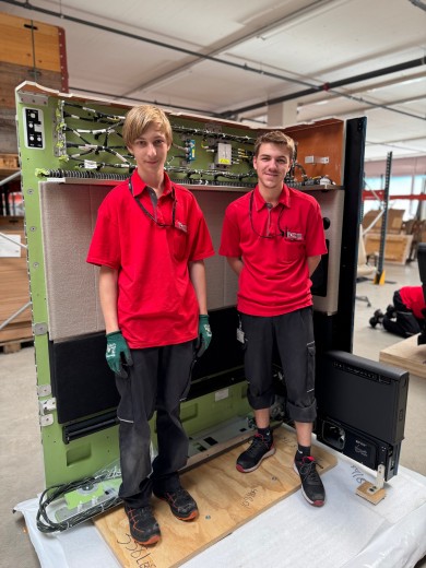 Julian and Paul in front of the rear wall of the SWISS First Suite Plus – just moments before it was securely fastened by our apprentices.