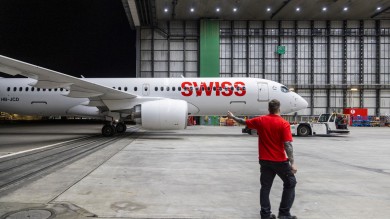 A mechanic is briefing the driver of the aircraft transporter.