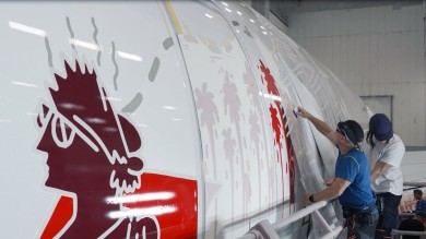 Craftsmanship in action: Technicians carefully apply individual film pieces by hand with millimeter precision on the aircraft fuselage and engines.