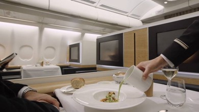 A SWISS First seat being served food