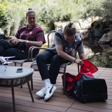 Patricia sits next to her open suitcase and points out the equipment she always has with her.