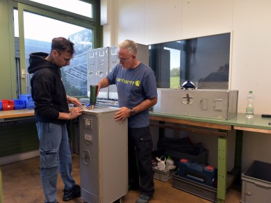 Remi und Francesco vom Züriwerk entfernen Klebereste mit dem Heissluftföhn.