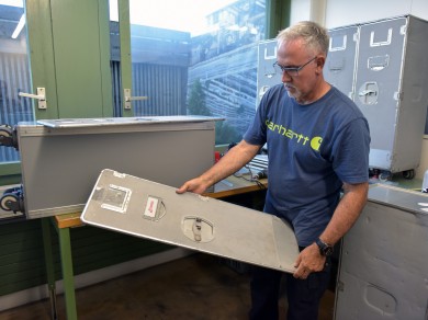 Remi vom Züriwerk hält eine von Gebrauchsspuren geprägte Trolleytür in der Hand.