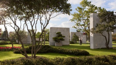 Garten mit Bäumen und futuristischen Betonwänden