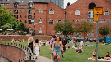  Im historischen Viertel Castlefield am Fluss Irwell sind zahlreiche Menschen mit dem Velo unterwegs, machen Picknicks auf den Grünflächen und geniessen die lebendige Atmosphäre dieses kulturellen Hotspots.