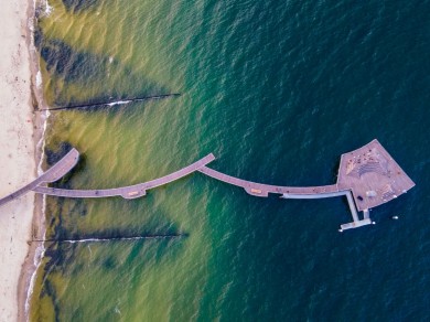 Die Seebrücke von Koserow – Die wellenförmige Brücke wurde 2021 eröffnet, führt elegant in die Ostsee und wird abends stimmungsvoll von LEDs beleuchtet.