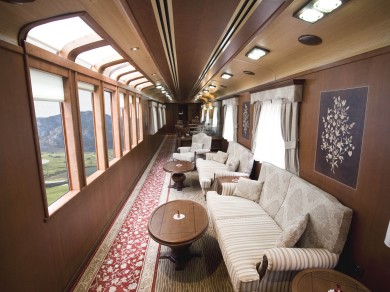 The elegant lounge aboard the Tren Transcantábrico, offering passengers a stunning panoramic view of Spain's lush northern coastline as they relax in a luxurious setting.