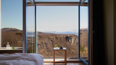 Im Wood Hotel rahmen bodentiefe Fenster weite Bergpanoramen und lassen die Gäste in die ungezähmte Schönheit Nordnorwegens eintauchen – eine harmonische Verbindung von Komfort und Natur.