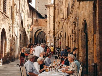 Menschen in Italien beim gemeinsamen Essen auf den belebten Strassen. 