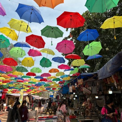 Weitere Stände sind zu sehen und das Highlight, bunte Schirme sind als Regenschutz als Dach aufgebaut worden.
