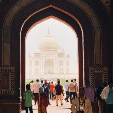 Mit vielen Menschen im Vordergrund, sieht man das Taj Mahal im Hintergrund.