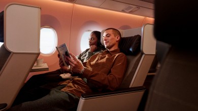 Passagierin schaut etwas vom inflight entertainment, Passagier liest ein Buch